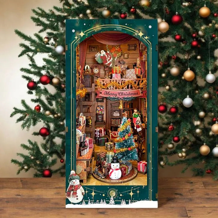 Book Nook - Christmas Jingle Cabin, un kit créatif pour construire un diorama miniature. Parfait pour décorer une bibliothèque ou comme cadeau original pour un amoureux des livres. Par Nookette.