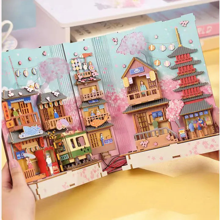 Book Nook - Sakura Bazaar, un kit créatif pour construire un diorama miniature. Parfait pour décorer une bibliothèque ou comme cadeau original pour un amoureux des livres. Par Nookette.