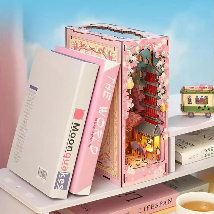Book Nook - Sakura Bazaar, un kit créatif pour construire un diorama miniature. Parfait pour décorer une bibliothèque ou comme cadeau original pour un amoureux des livres. Par Nookette.