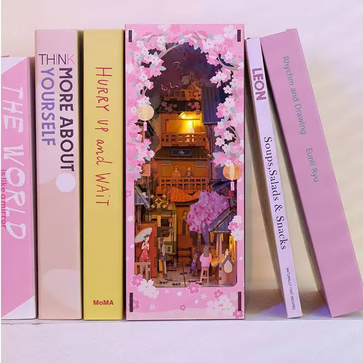 Book Nook - Sakura Bazaar, un kit créatif pour construire un diorama miniature. Parfait pour décorer une bibliothèque ou comme cadeau original pour un amoureux des livres. Par Nookette.