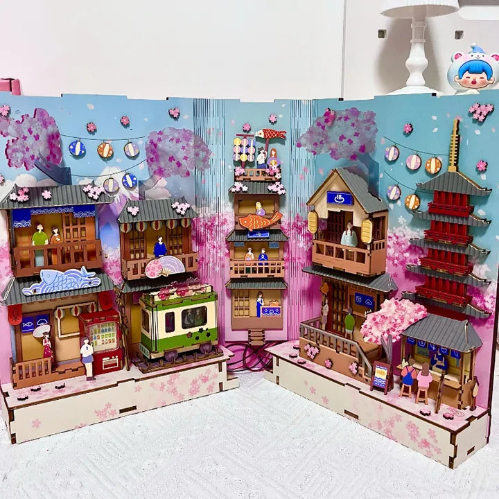 Book Nook - Sakura Bazaar, un kit créatif pour construire un diorama miniature. Parfait pour décorer une bibliothèque ou comme cadeau original pour un amoureux des livres. Par Nookette.