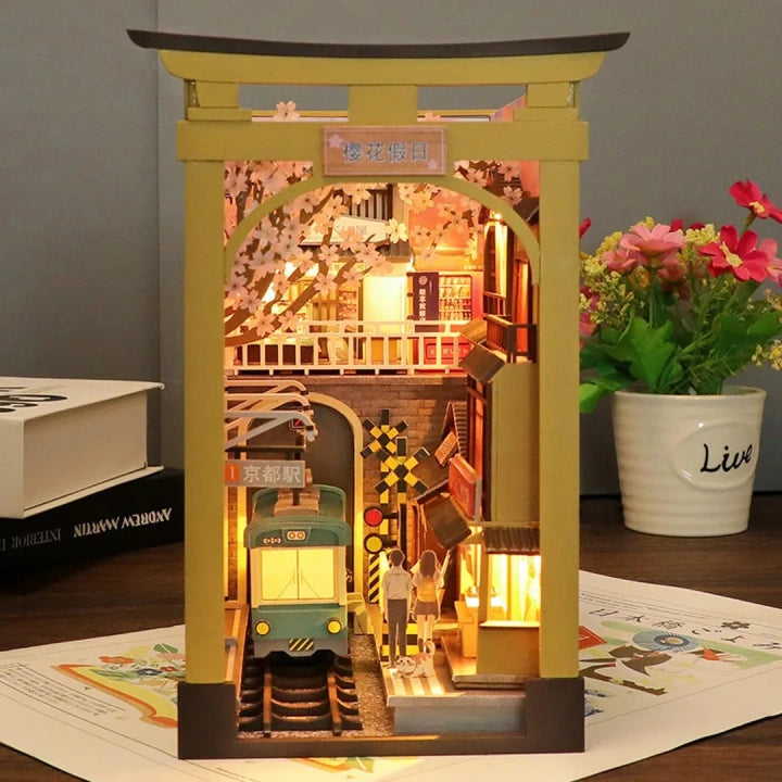 Book Nook - Sakura Holiday, un kit créatif pour construire un diorama miniature. Parfait pour décorer une bibliothèque ou comme cadeau original pour un amoureux des livres. Par Nookette.