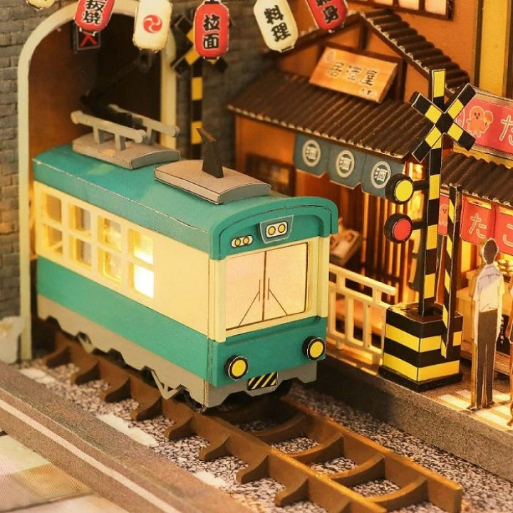 Book Nook - Sakura Holiday, un kit créatif pour construire un diorama miniature. Parfait pour décorer une bibliothèque ou comme cadeau original pour un amoureux des livres. Par Nookette.