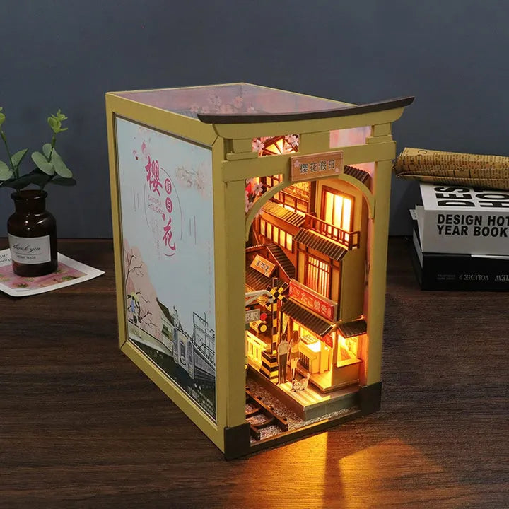 Book Nook - Sakura Holiday, un kit créatif pour construire un diorama miniature. Parfait pour décorer une bibliothèque ou comme cadeau original pour un amoureux des livres. Par Nookette.