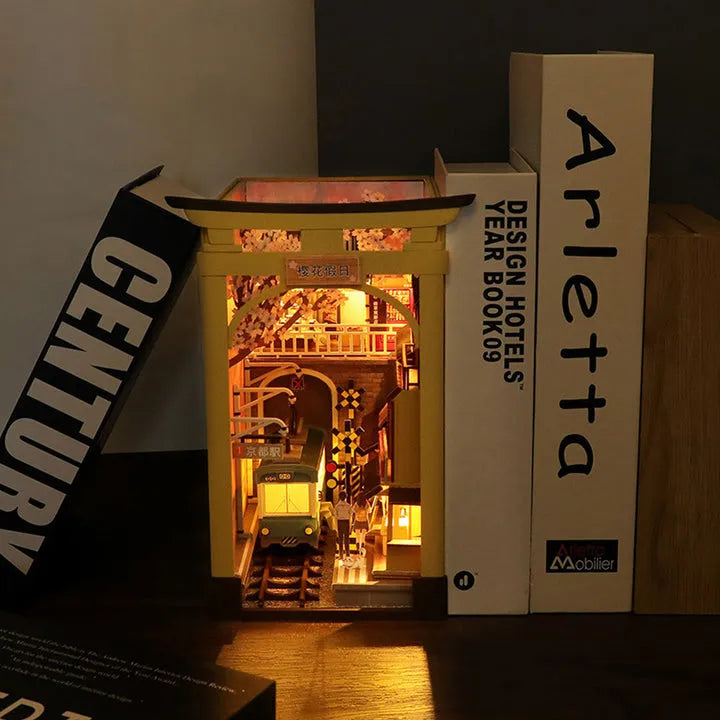 Book Nook - Sakura Holiday, un kit créatif pour construire un diorama miniature. Parfait pour décorer une bibliothèque ou comme cadeau original pour un amoureux des livres. Par Nookette.