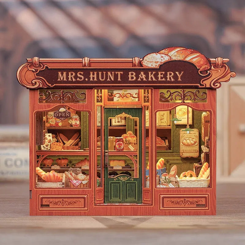 Maison Miniature - Mrs. Hunt Bakery, un kit créatif pour construire un diorama miniature. Parfait pour décorer une bibliothèque ou comme cadeau original pour un amoureux des livres. Par Nookette.
