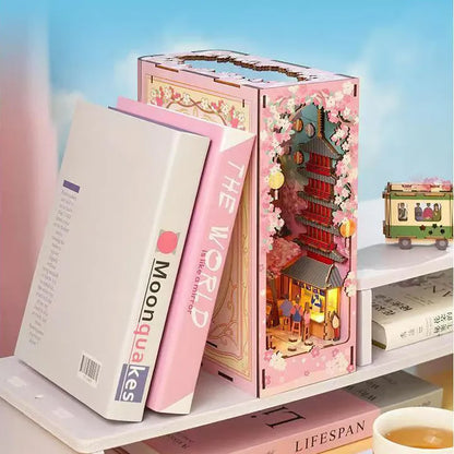 Book Nook - Sakura Bazaar, un kit créatif pour construire un diorama miniature. Parfait pour décorer une bibliothèque ou comme cadeau original pour un amoureux des livres. Par Nookette.