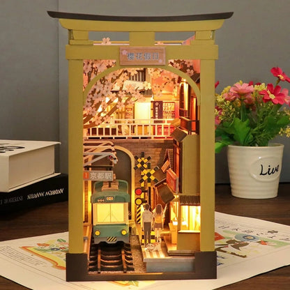 Book Nook - Sakura Holiday, un kit créatif pour construire un diorama miniature. Parfait pour décorer une bibliothèque ou comme cadeau original pour un amoureux des livres. Par Nookette.