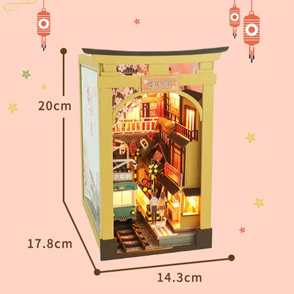 Book Nook - Sakura Holiday, un kit créatif pour construire un diorama miniature. Parfait pour décorer une bibliothèque ou comme cadeau original pour un amoureux des livres. Par Nookette.