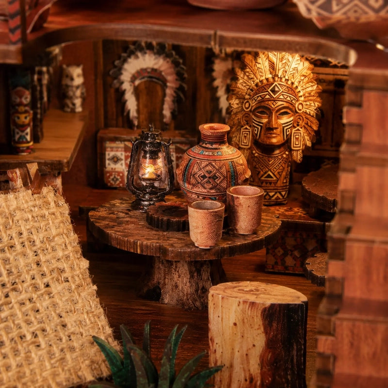 Deux tasses et une lanterne miniature occupent une table ronde d’aspect brut. Autour d’elles, les objets et les motifs donnent au niveau inférieur son caractère de lieu habité.